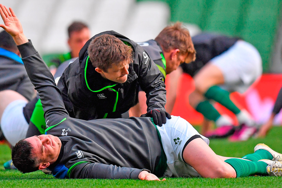 Jonathan Sexton receives treatment from team physio Colm Fuller during the Ireland Rugby captain's run at the Aviva Stadium in Dublin. Photo: Sportsfile