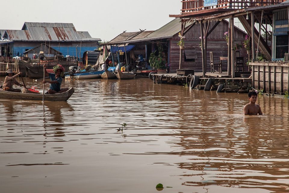 Residents of the floating village of Mechrey ride a boat