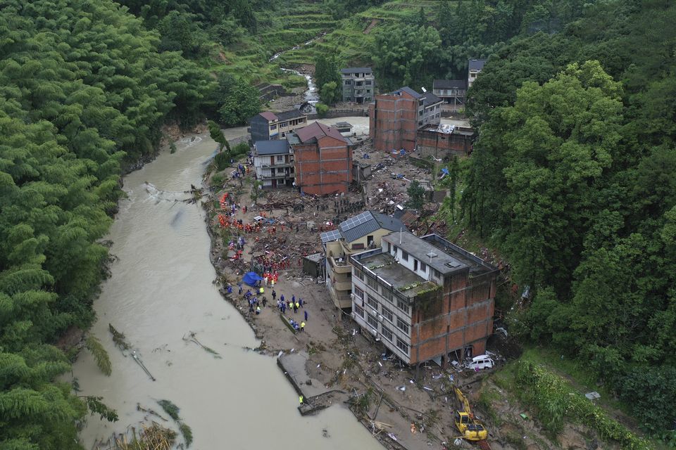 Rescuers search for victims of a landslide triggered by Typhoon Lekima in eastern China (Chinatopix/AP)