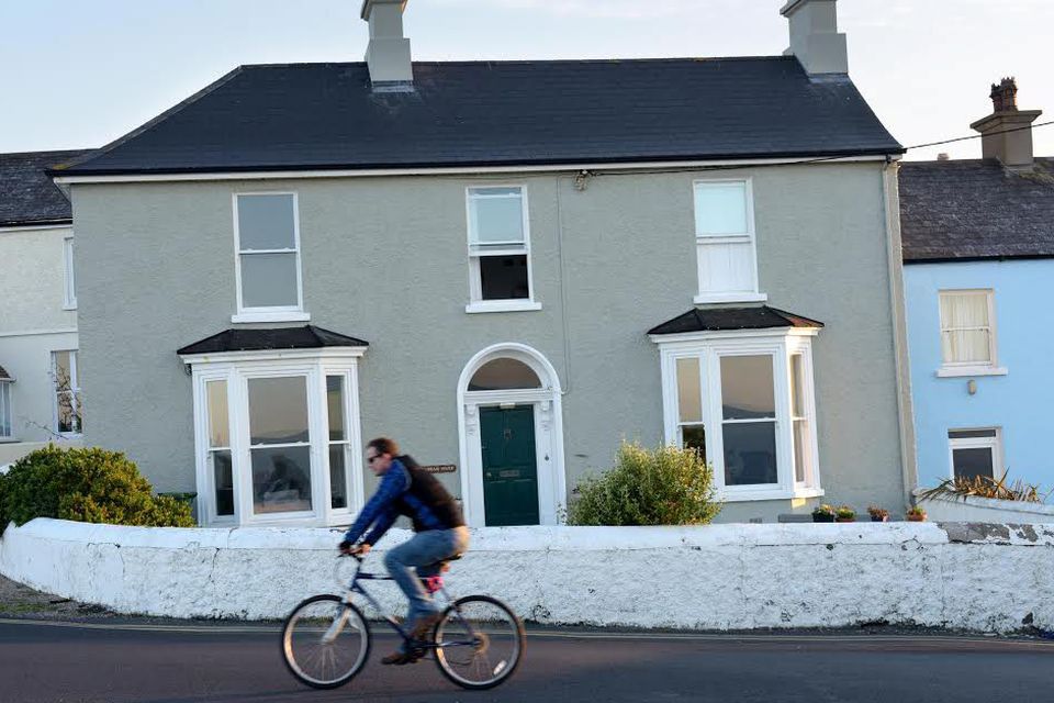 A man cycles past a house in Greystones