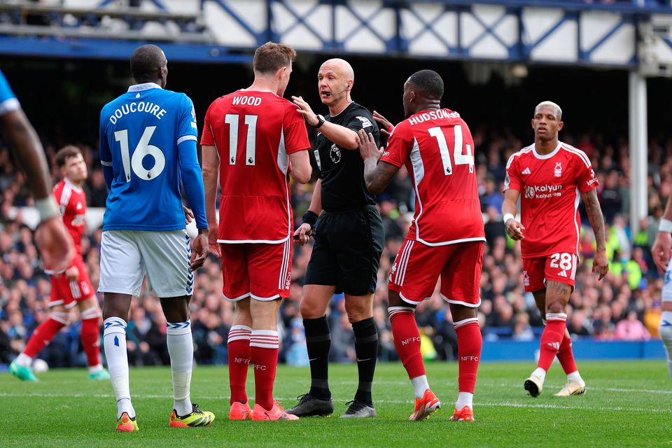 Referee Anthony Taylor is confronted by Chris Wood and Callum Hudson-Odoi of Nottingham Forest claiming a hand ball against Ashley Young of Everton (not pictured) during the Premier League match at Goodison Park