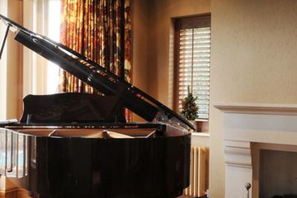 A grand piano sits  in the reception room