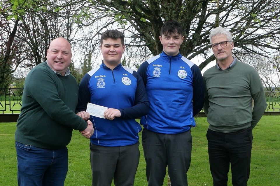 Cllr Anthony Connick receiving a cheque from senior prefects, Evan Morrissey and Billy Byrne.