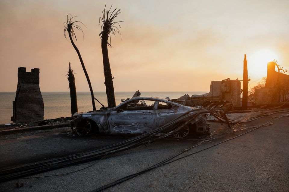 A burnt car next to beachfront homes in ruins along the road to Malibu. Photo: Reuters