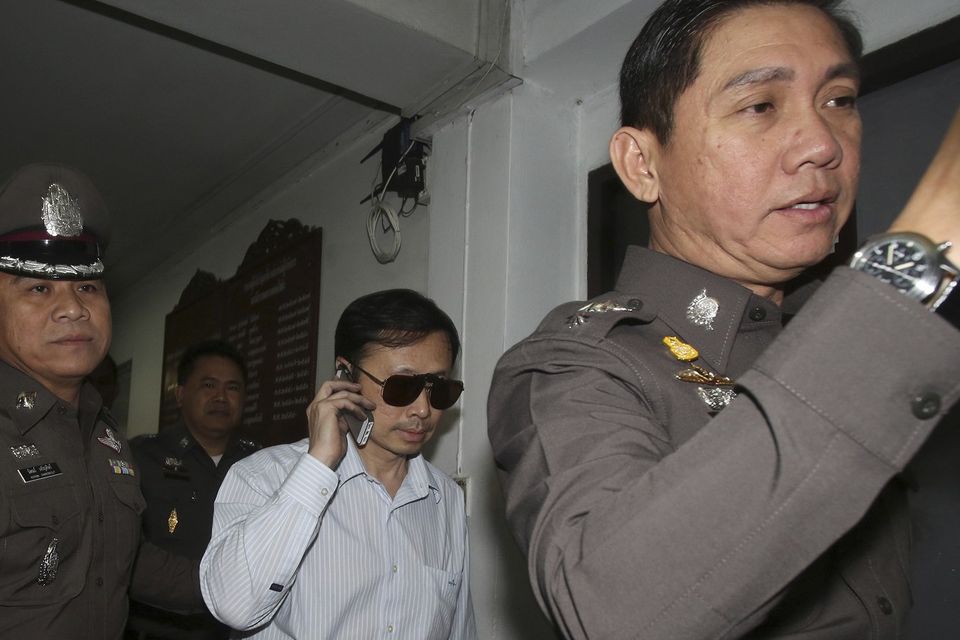 Doctor Sompob Sansiri is escorted by Thai police officers (AP)