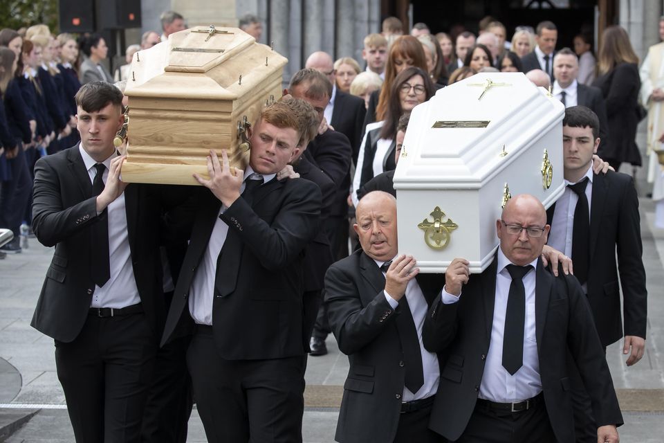 Luke and Grace's father, Paul (centre right), helps carry the remains while the siblings' mother Brigid (centre) walks behind at the joint funeral on Friday, September 1. Luke (24) and Grace (18) McSweeney, Zoey Coffey (18) and Nicole Murphy (18) died in a car accident in Clonmel, Co Tipperary, on Friday, August 25. Photo: Colin Keegan, Collins Dublin