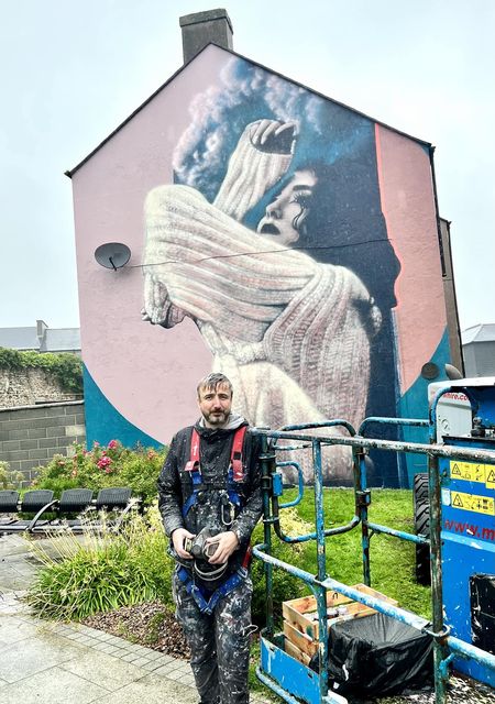 El artista Eoin McGinn con su último trabajo en Abbey Street, frente al Wexford Arts Centre.