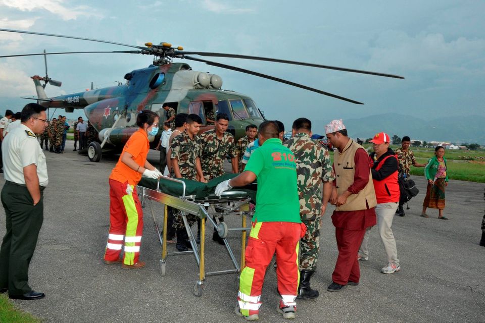 Nepalese army personnel assist a victim of a bus accident after being airlifted from Birtadeurali in Kavre to Kathmandu, Nepal, August 15, 2016. Nepalese Army/Handout via REUTERS