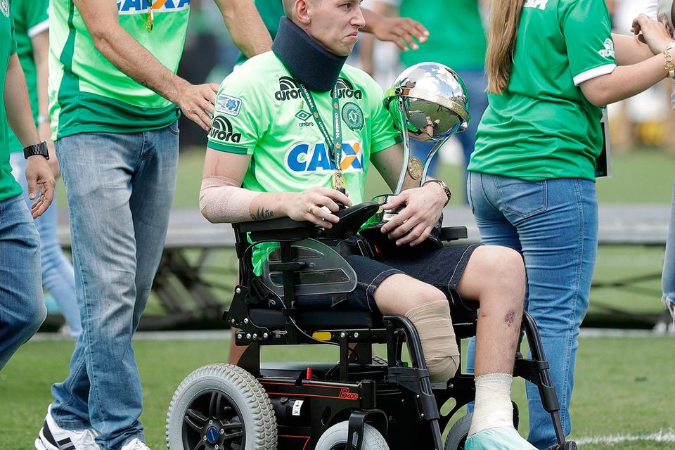 Chapecoense goalkeeper Follmann, one of the three players that survived the air crash almost two months ago, is wheeled on the pitch as he carries the Sudamericana trophy, during the Sudamericana trophy award ceremony prior to a match against Palmeiras, in Chapeco, Brazil