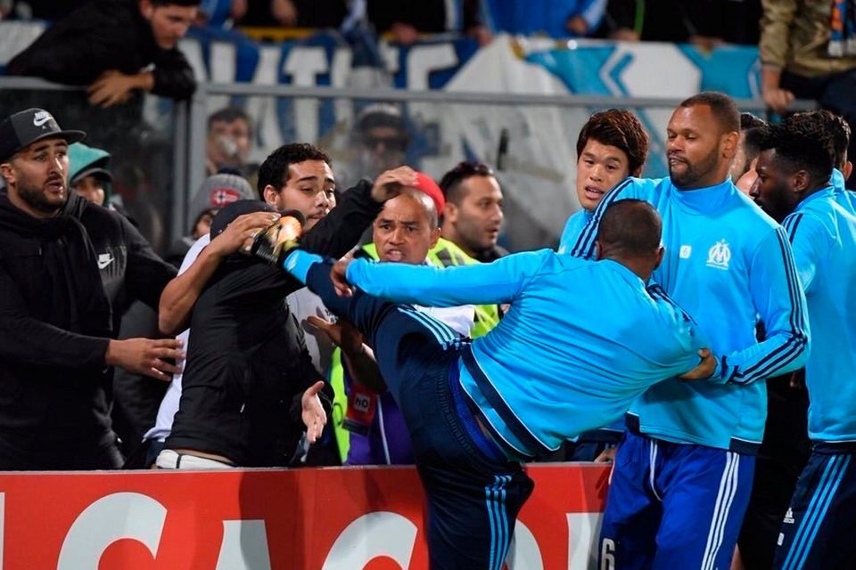 Patrice Evra kicks out at a Marseille fan prior to last night’s Europa League game against Vitoria in Portugal