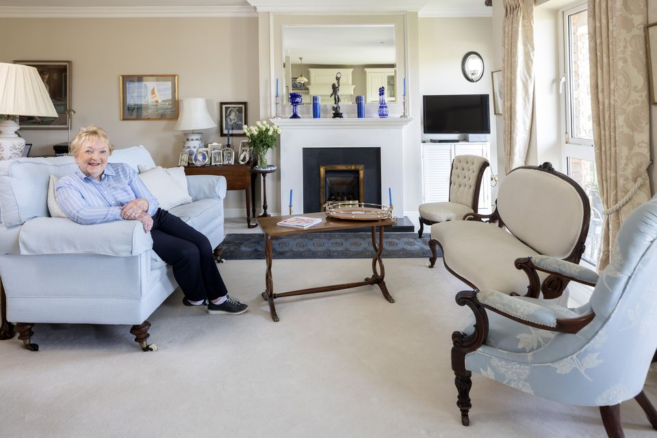 Violinist Ursula Hough-Gormley in the elegant living room of her apartment in Dublin 4. Ursula has opted for blue, cream and gold decor and is furnished with a mix of modern pieces and antiques.  The blue glass of the fireplace is a hand-painted Venetian chandelier.  The paintings include a portrait of her late husband as a tailor's apprentice by Bob McDonagh.  Photo: Tony Gavin