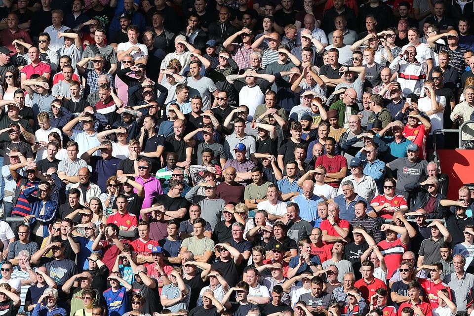 Manchester United fans shield their eyes from the sun during the Premier League match between Southampton and Manchester United at St Mary's Stadium on September 23, 2017 in Southampton, England.  (Photo by John Peters/Man Utd via Getty Images)