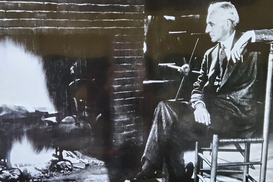 Henry Ford at the fireplace of his home at Fair Lane