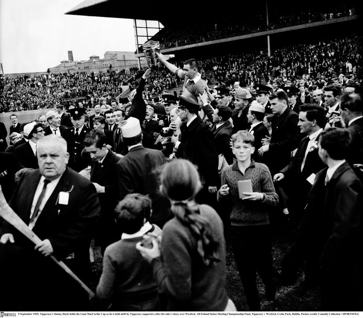 Tipperary's Jimmy Doyle holds the Liam MacCarthy Cup as he is held aloft by Tipperary supporters after his side's vitory over Wexford in 1965. All Ireland Senior Hurling Championship Final, Tipperary v Wexford, Croke Park, Dublin. Picture credit; Connolly Collection / SPORTSFILE