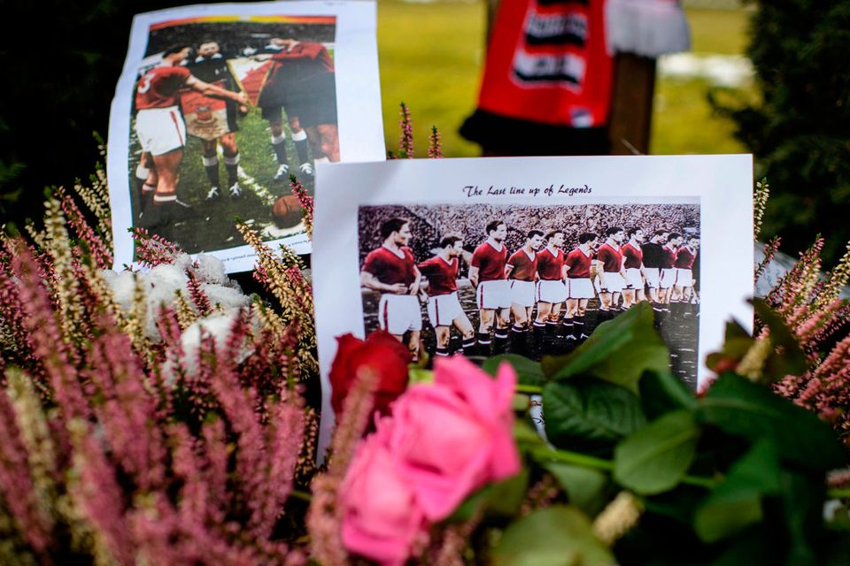 A Team photo of the forme Manchester United soccer club and flowers are placed next to a memorial during a commemoration ceremony on the Manchester place at the Munich Riem airport, southern Germany, Tuesday, Feb. 6, 2018. Sixty years ago on Feb. 6, 1958 a plane with professional players of the Manchester United on board crashed in Munich with 21 survivors and 23 fatalities. (Matthias Balk/dpa via AP)