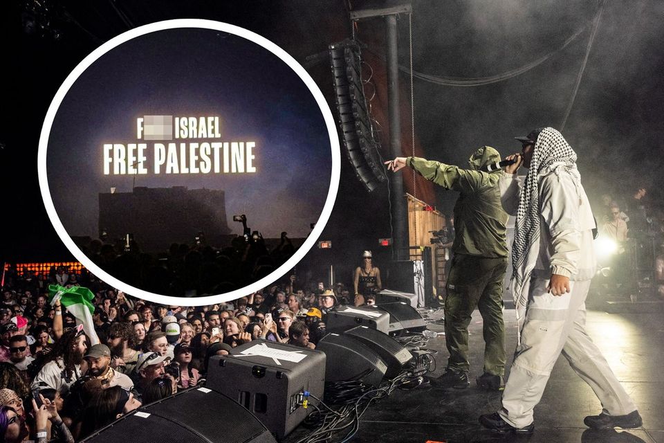 Kneecap on stage, with the message in the background
