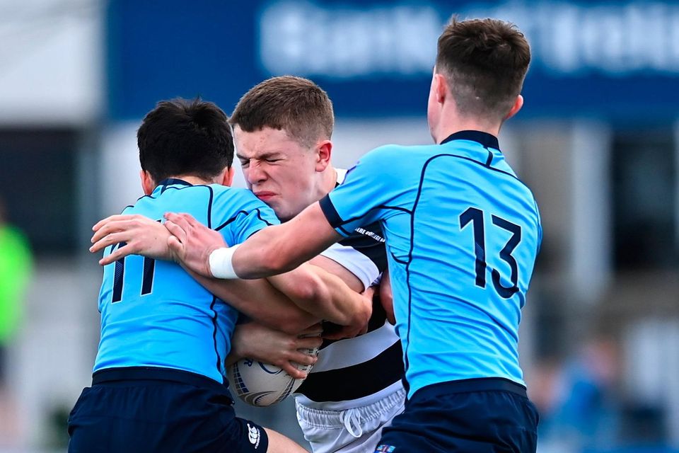 Belvedere College's Paul Dunne is tackled by Eoin Loo, left, and Matthew Haugh of St Michael's College in their Leinster Schools Junior Cup semi-final replay. Photo by: Ben McShane/Sportsfile