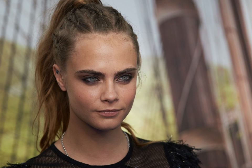 British model and actress Cara Delevingne poses for photographers as she arrives for the World Premiere of "PAN" in London's Leicester Square