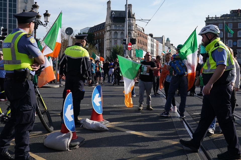 Garda public order units deployed as anti-immigration protesters block O’Connell Bridge, leading to delays for commuters and Luas disruptions