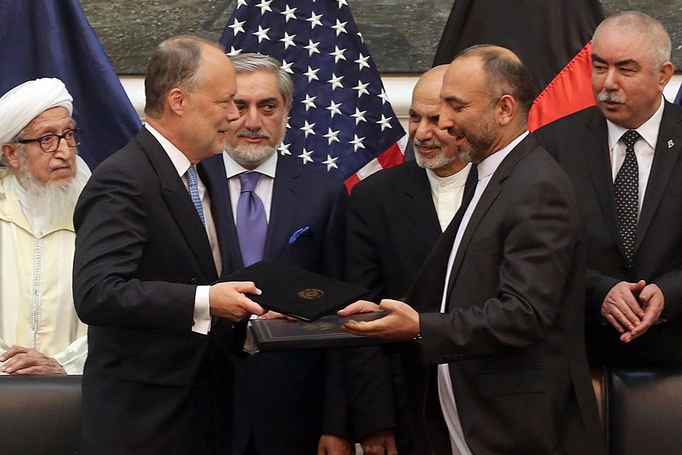 US ambassador James Cunningham and Afghan security chief Mohmmad Hanif Atmar exchange documents in Kabul. (AP)