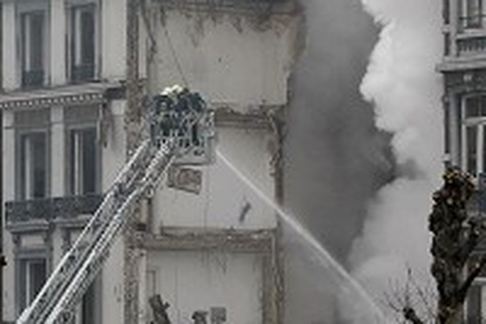Firemen try to extinguish a fire in a collapsed building in Liege, in Belgium (AP)