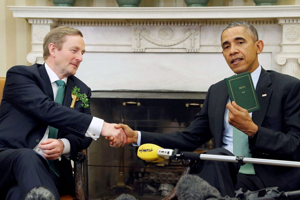 U.S. President Barack Obama holds a book of poetry by William Butler Yeats given to him by Ireland's Prime Minister Enda Kenny (L) during their meeting in the Oval Office as part of a St. Patricks Day visit at the White House in Washington March 17 2015. REUTERS/Jonathan Ernst