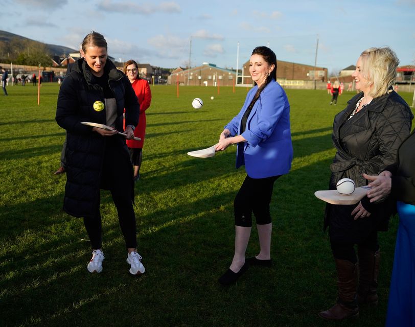 Deputy First Minister Emma Little-Pengelly (centre) and Junior Minister Aisling Reilly (left) during a visit to St. Paul's GAA club in west Belfast. Photo: Niall Carson/PA Wire 