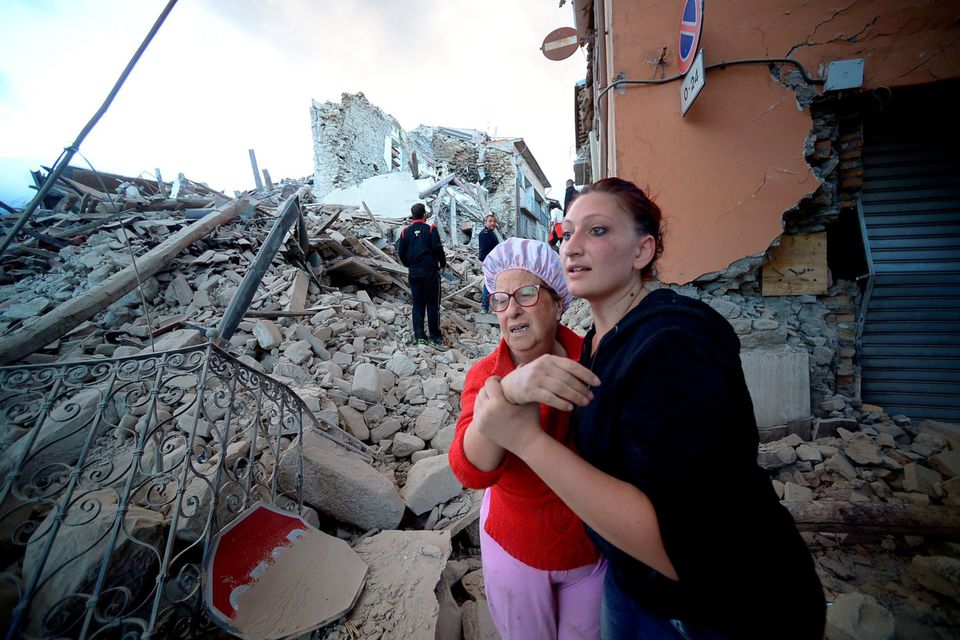 Shocked residents react among the rubble after the powerful quake devastated the town of Amatrice Picture: AFP