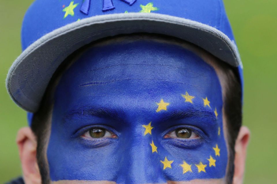 A man with the flag of the European Union painted on his face
