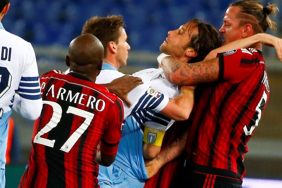 AC Milan's Philippe Mexes (R) reacts with Lazio's Stefano Mauri (2nd R) during their Italian Serie A soccer match at the Olympic stadium in Rome