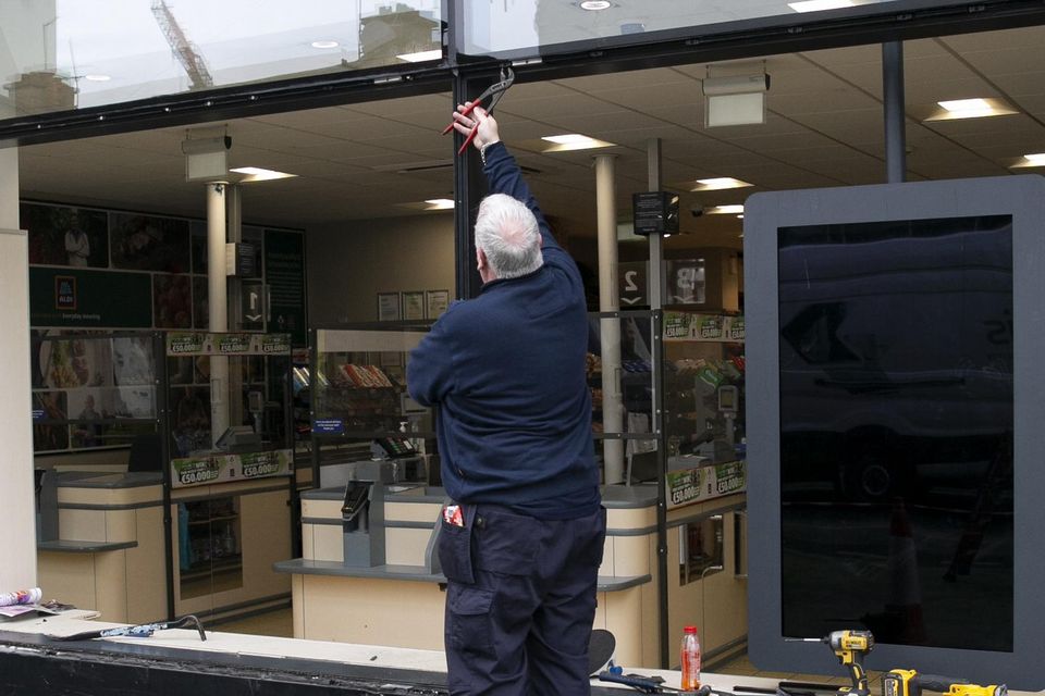 A workman outside the Aldi store in Rathmines after an incident in which a car smashed the window. Photo: Collins