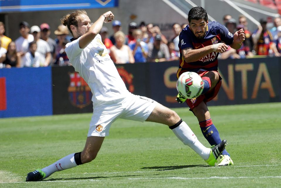 FC Barcelona's Luis Suarez, right, attempts a shot against Manchester United's Daley Blind during the first half of an International Champions Cup soccer match in Santa Clara, Calif., Saturday, July 25, 2015. (AP Photo/Jeff Chiu)