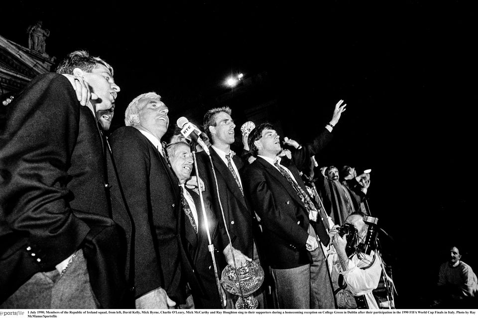 1 July 1990; Members of the Republic of Ireland squad, from left, David Kelly, Mick Byrne, Charlie O'Leary, Mick McCarthy and Ray Houghton sing to their supporters during a homecoming reception on College Green in Dublin after their participation in the 1990 FIFA World Cup Finals in Italy. Photo by Ray McManus/Sportsfile