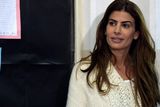 thumbnail: Juliana Awada wife of Buenos Aires Mayor and presidential candidate for "Cambiemos" party Mauricio Macri waits to her husband while voting at a polling station in Buenos Aires on October 25, 2015
