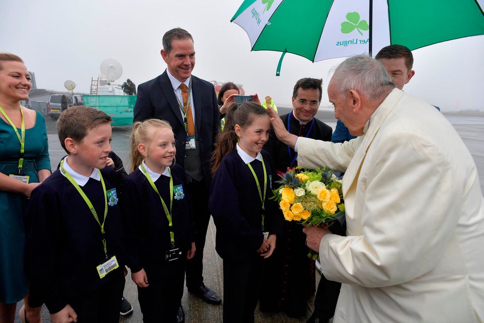 Pope Francis receives flowers from children after arriving in Knock, Ireland August 26, 2018. Vatican Media/Handout