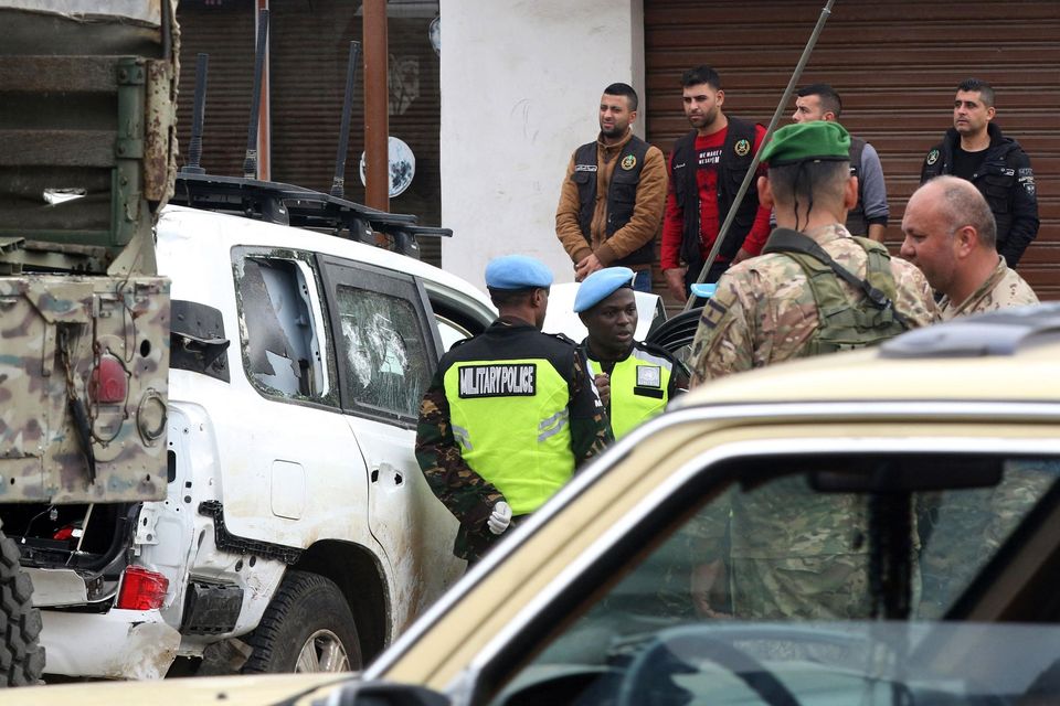 Members of the UN peacekeepers forces and Lebanese soldiers gather near a bullet-riddled car at the site where a UN peacekeeping force UNIFIL convoy came under small arms fire, in the village of Aqibya in south Lebanon, on December 15, 2022. - An Irish soldier of the UN peacekeeping force in south Lebanon near the Israeli border was killed and three wounded, Irish officials said. (Photo by Mahmoud ZAYYAT / AFP) (Photo by MAHMOUD ZAYYAT/AFP via Getty Images)