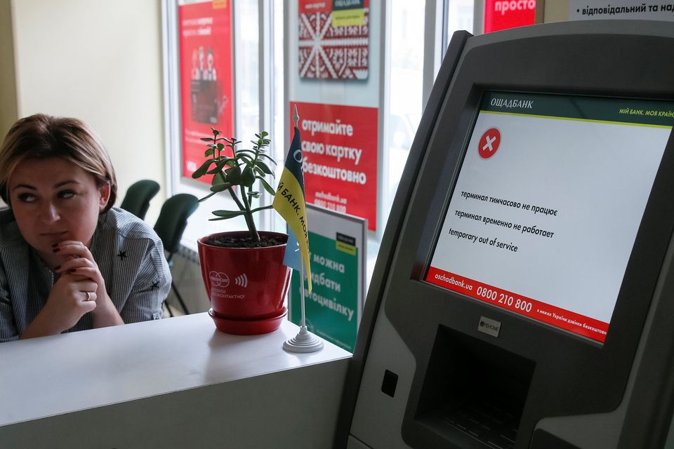 An employee sits next to a hacked payment terminal at a branch of Ukraine’s
state-owned bank Oschadbank. Picture: Reuters