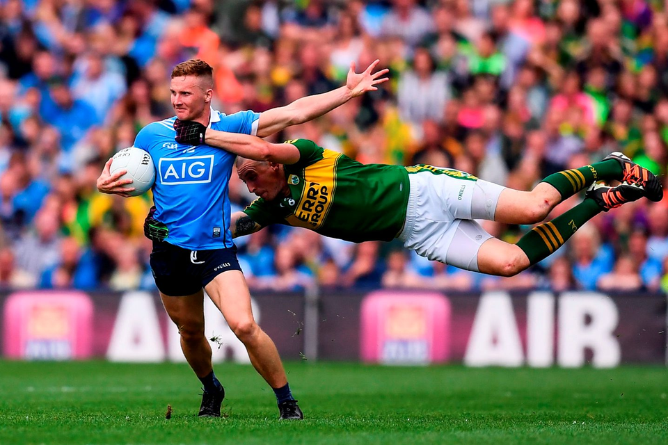 Kerry's Kieran Donaghy is in full flight as he attempts to stop the charge of Dublin's Ciaran Kilkenny. Photo: Sportsfile