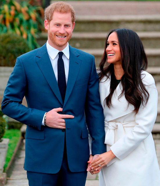 Britain's Prince Harry and his fiancée US actress Meghan Markle pose for a photograph in the Sunken Garden at Kensington Palace in west London on November 27, 2017, following the announcement of their engagement