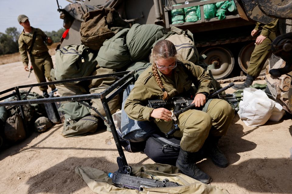 An Israeli soldier cleans her weapon near the Israel-Gaza border yesterday. Photo: Reuters