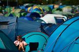 thumbnail: A reveller sits among the tents at the Glastonbury Festival of Music and Performing Arts on Worthy Farm near the village of Pilton in Somerset, South West England, on June 26, 2019. (Photo by Oli SCARFF / AFP)OLI SCARFF/AFP/Getty Images