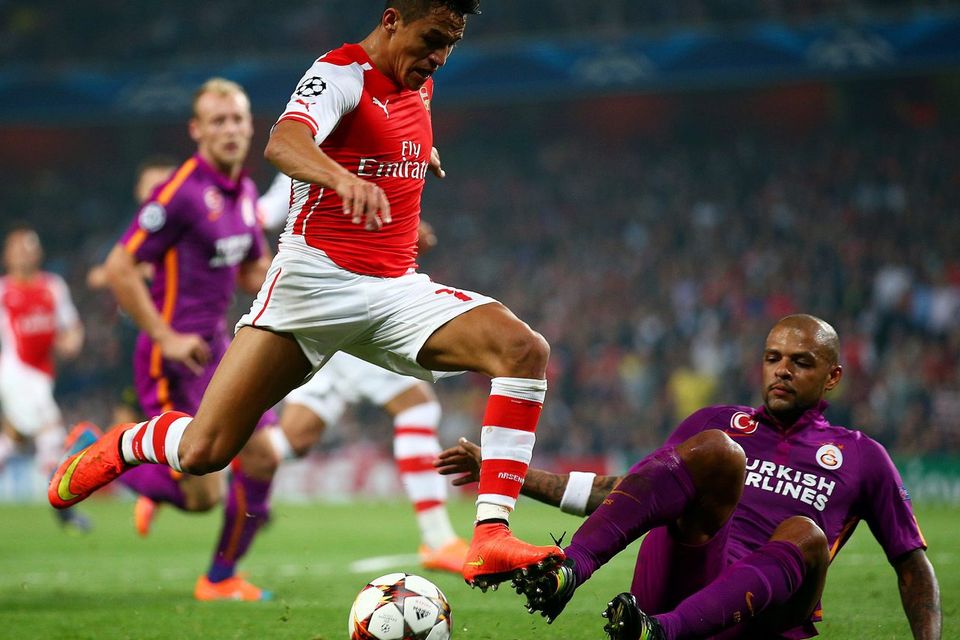 Arsenal forward Alexis Sanchez skips over a challenge from Galatasaray's Felipe Melo during the UEFA Champions League game at the Emirates. Photo: Paul Gilham/Getty Images