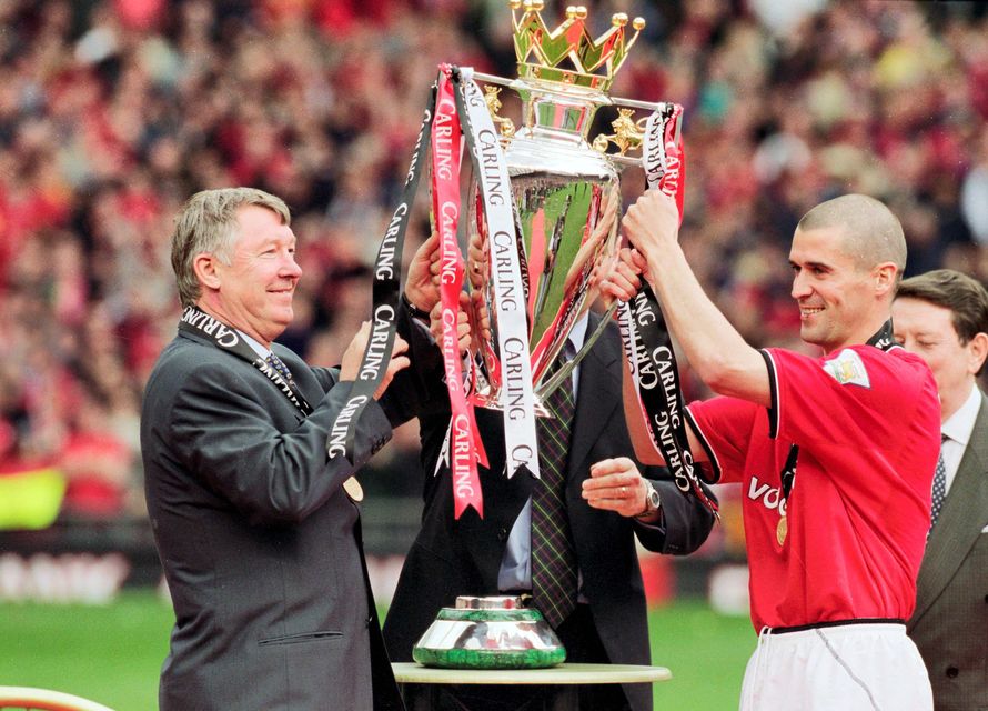 Manchester United manager Alex Ferguson and former team captain Roy Keane share a moment of celebration, as they hoist the Premier League trophy in Old Trafford, in 2001.